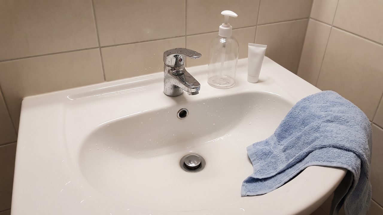 A wet basin with an unlabelled pump bottle and a small tube on the rim